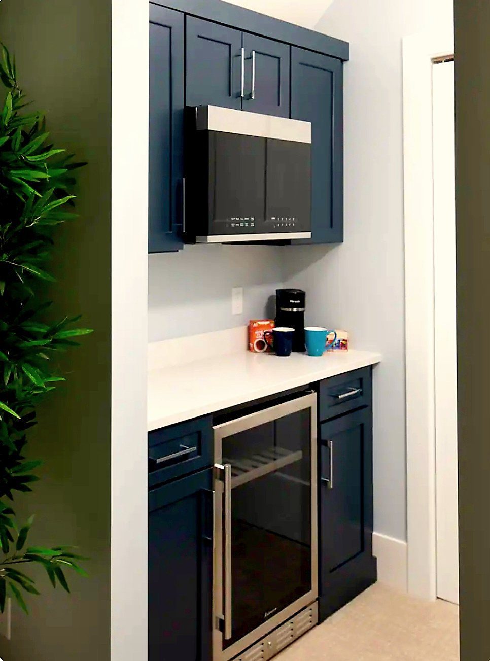 En-suite kitchenette with navy cabinetry, microwave, beverage cooler, and coffee maker